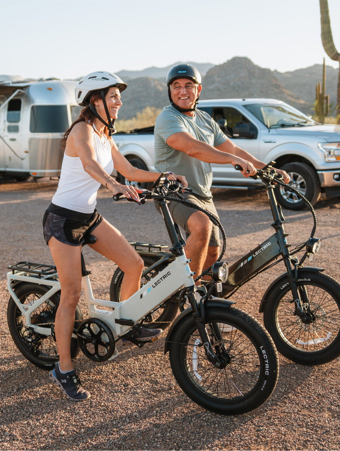 Man and woman riding Lectric XP4 eBikes at camping location